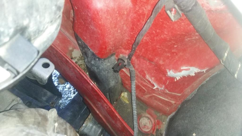 Prasknutý a vyhnutý lak v podbehu pri kábelovom zväzku – zrejme nehoda cez predný tlmič